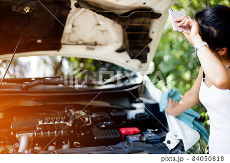 Business women have car problems on the side of the road.The light is golden at sunset. Young women calling car mechanic. Concept of quality inspection of cars Engine maintenance all the time. Business women have car problems on the side of the road.The light is golden at sunset. Young women calling car mechanic. Concept of quality inspection of cars Engine maintenance all the time. 84050818
