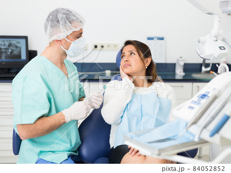 Woman complains of toothache to dentist 84052852