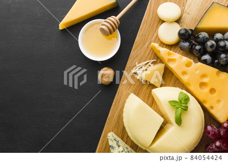 flat lay mix gourmet cheese grapes cutting board with honey. High quality beautiful photo concept flat lay mix gourmet cheese grapes cutting board with honey. High quality beautiful photo concept 84054424