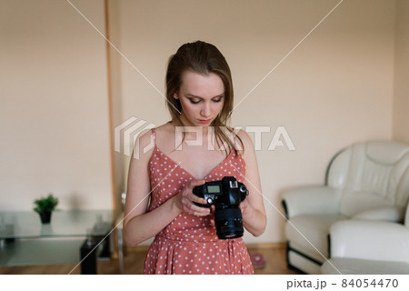 Freelance photographer woman with camera at home office editing photos on a computer 84054470