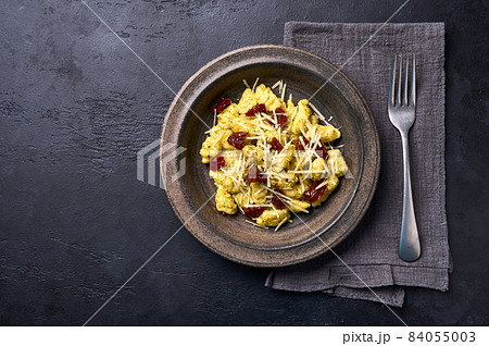 Mediterranean and Alpine potato gnocchi with parmesan and dried tomatoes in ceramic plate. Flat lay Mediterranean and Alpine potato gnocchi with parmesan and dried tomatoes in ceramic plate. Flat lay 84055003