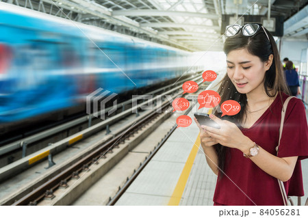 Asian woman passenger using mobile phone to check social network application with number of Like, Love, comment, people and fovorite icon in the Skytrain rails or subway in city, Social media concept, Asian woman passenger using mobile phone to check social network application with number of Like, Love, comment, people and fovorite icon in the Skytrain rails or subway in city, Social media concept, 84056281