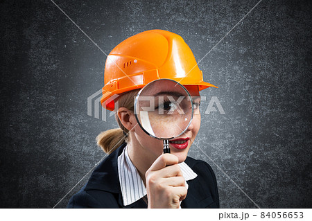 Building inspector looking through magnifier Building inspector looking through magnifier 84056653