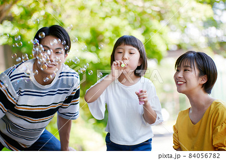 しゃぼん玉で遊ぶ若いファミリー 84056782