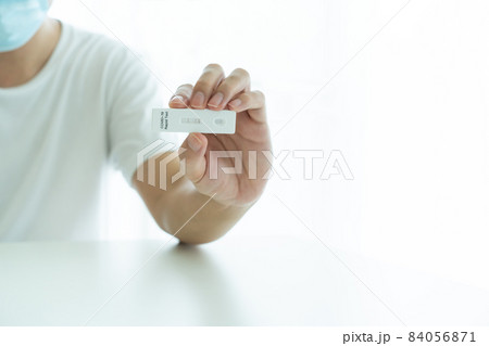 Man showing covid-19 ag testing result. Man showing covid-19 ag testing result. 84056871