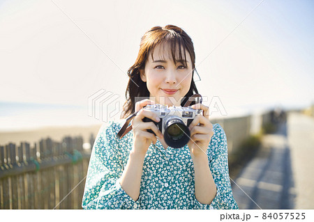 海辺で微笑む女性の写真 海辺でカメラを持って微笑む女性の写真素材 [84057525] - PIXTA