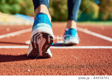 Blue sport shoes at stadium track 84058701