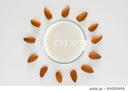 A glass of almond milk on a white background. Lactose-free vegetable diet milk. Gluten free almond drink on a blue background. Super Food - A glass of almond milk for a healthy diet. Trending food, 84060466