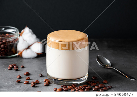 Dalgona coffee on a black background. Making a trendy drink. Fluffy sweet foam in a glass with ice milk. Dalgona coffee on a black background. Making a trendy drink. Fluffy sweet foam in a glass with ice milk. 84060477