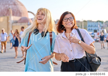 Mother and teenage daughter walking together in the old tourist town. 84060646