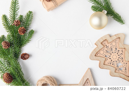 Christmas background frame of fir twigs and wooden home decoration chistmas tree on white background, top view. Christmas background frame of fir twigs and wooden home decoration chistmas tree on white background, top view. 84060722