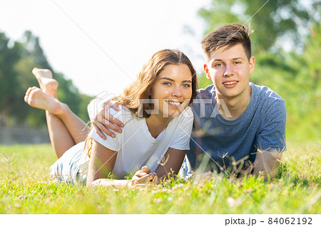 Cheerful girl with friend are resting on grass 84062192