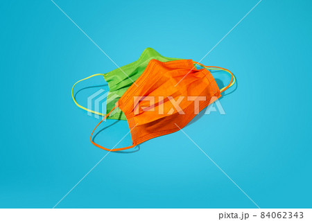 Protective colourful face masks on bright background. Protective colourful face masks on bright background. 84062343