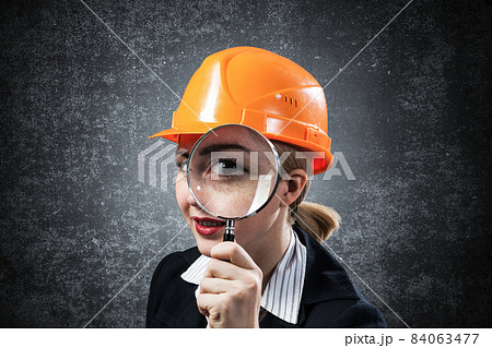 Building inspector looking through magnifier Building inspector looking through magnifier 84063477