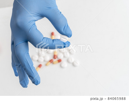 Holding medication pills with surgical glove 84065988