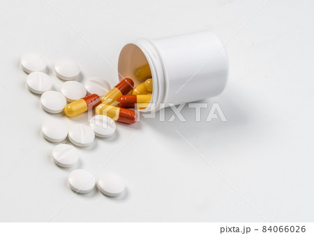 Pills and capsules falling out of a container Pills and capsules falling out of a container 84066026