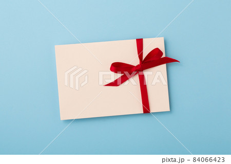 Letter with red bow ribbon on blue background 84066423