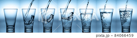 pouring water in glass with reflection on white background pouring water in glass with reflection on white background 84066459