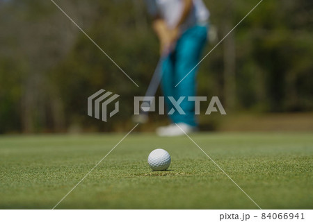 Blurred golfer playing golf in the evening golf course, on sun set evening time. Man playing golf on a golf course in the sun. Blurred golfer playing golf in the evening golf course, on sun set evening time. Man playing golf on a golf course in the sun. 84066941
