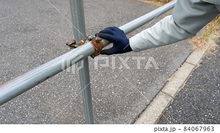単管手すり｜クランプのサビを確認する作業員 84067963