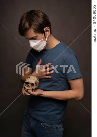 Young man with face mask on grey 84069905