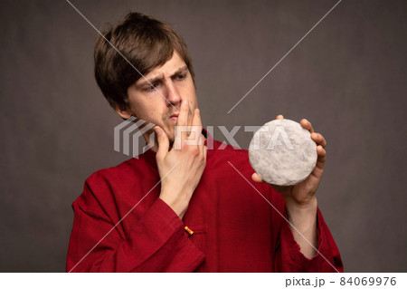 Young man in red shirt on grey Young man in red shirt on grey 84069976