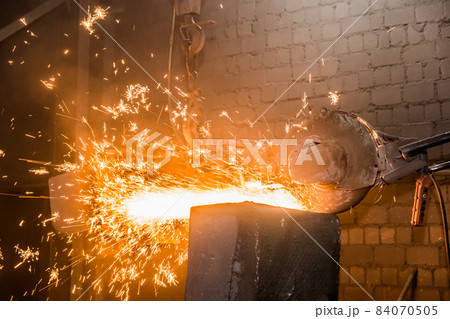Heavy grinding equipment suspended on a chain with a hook processes and cleans cast iron reinforced concrete tubing in the workshop of an industrial plant Heavy grinding equipment suspended on a chain with a hook processes and cleans cast iron reinforced concrete tubing in the workshop of an industrial plant 84070505