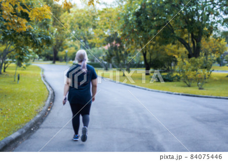 Blurred concept of overweight woman exercise walking in the park. Blurred concept of overweight woman exercise walking in the park. 84075446