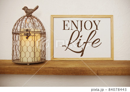 Blackboard with the text ENJOY LIFE decorate with artificial plant in watering plant on wooden shelves 84078443