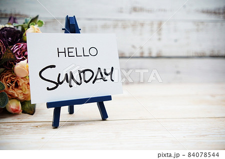 Hello Sunday text with flower bouquet on wooden background 84078544