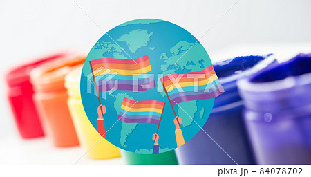 Image of rainbow flags over globe with paints in background 84078702