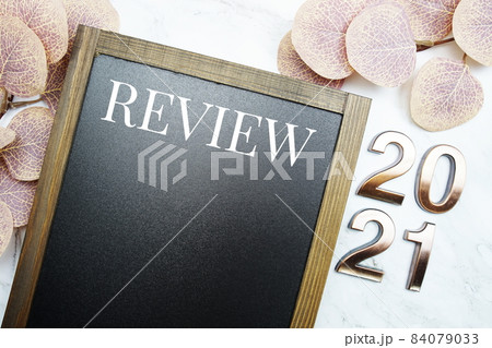 Review 2021 with space copy on blackboard with eucalyptus leaves on marble background 84079033