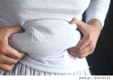 man's hand holding excessive belly fat, overweight concept man's hand holding excessive belly fat, overweight concept 84079434