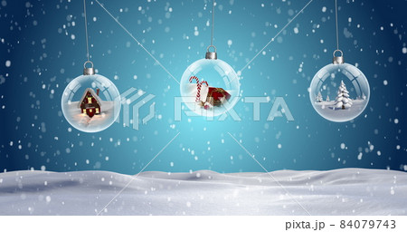 Three clear Christmas baubles dangling against snowflakes falling on snow landscape Three clear Christmas baubles dangling against snowflakes falling on snow landscape 84079743