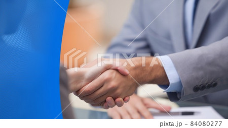 Composition of businessmen shaking hands with blue mesh border 84080277
