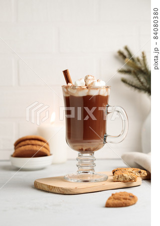 Cocoa or hot chocolate with marshmallows in a tall mug, on a wooden stand with cookies. Vertical, on a light background, with space Cocoa or hot chocolate with marshmallows in a tall mug, on a wooden stand with cookies. Vertical, on a light background, with space 84080380