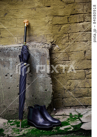 Men's shoes with an umbrella and a walking stick are on the street Men's shoes with an umbrella and a walking stick are on the street 84080918
