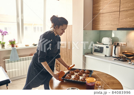 Professional confident woman is preparing custard cakes at light modern kitchen at home 84083996