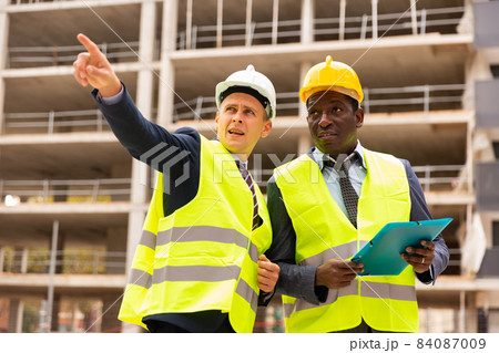 Two architect, civil engineer or building contractor colleagues on construction site 84087009