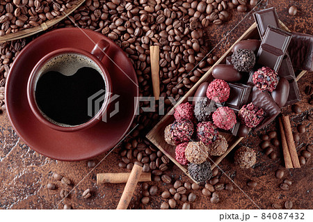 Various chocolates in wooden dish on a brown table. 84087432