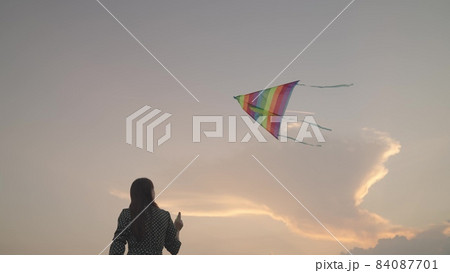 Free girl launches a kite into the sunset sky, have fun on the journey, play in the fun outdoors of nature, dream to fly, women's weekend with rainbow color play in nature, catch the wind high above Free girl launches a kite into the sunset sky, have fun on the journey, play in the fun outdoors of nature, dream to fly, women's weekend with rainbow color play in nature, catch the wind high above 84087701