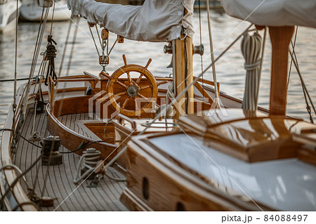 A close-up of instruments and wooden wheel of nautical vessel. Sailboat at sea background 84088497