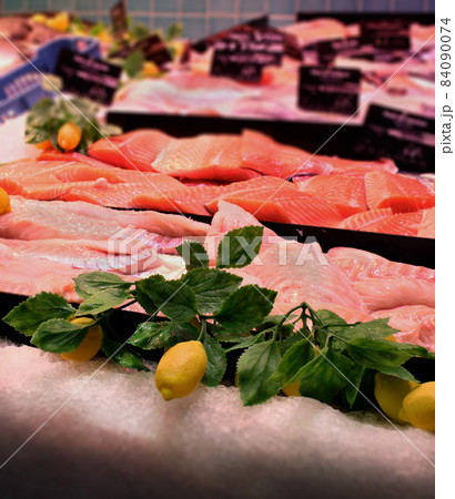 Fish market showcase with tuna and salmon meat and artificial lemon branches and fruit Fish market showcase with tuna and salmon meat and artificial lemon branches and fruit 84090074
