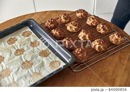 Professional confident woman is preparing custard cakes at light modern kitchen at home Professional confident woman is preparing custard cakes at light modern kitchen at home 84090856