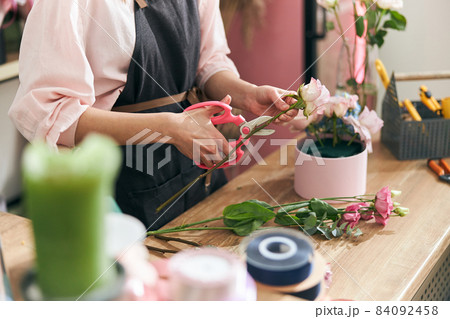 Professional florist young woman is doing bouquets at flower shop Professional florist young woman is doing bouquets at flower shop 84092458