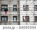 scaffolding workers place the facade over lines and points 84095094