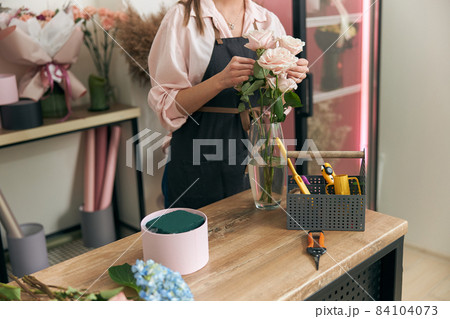 Professional florist young woman is doing bouquets at flower shop Professional florist young woman is doing bouquets at flower shop 84104073