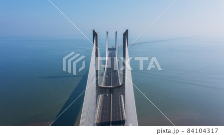 Aerial view of the most beautiful Portuguese bridge in Lisbon, Vasco da Gama. Morning foggy seascape. 84104317