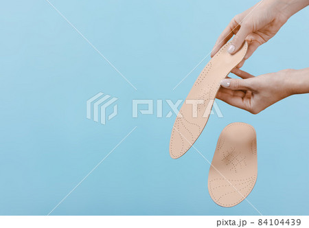 Orthopedic insole isolated on a blue background. Medical insoles. Treatment and prevention of flat feet and foot diseases. Foot care, feet comfort. Wear comfortable shoes. Flat Feet Correction. Orthopedic insole isolated on a blue background. Medical insoles. Treatment and prevention of flat feet and foot diseases. Foot care, feet comfort. Wear comfortable shoes. Flat Feet Correction. 84104439