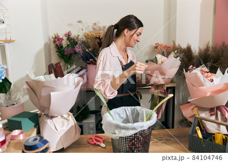 Professional florist young woman is doing bouquets at flower shop 84104746